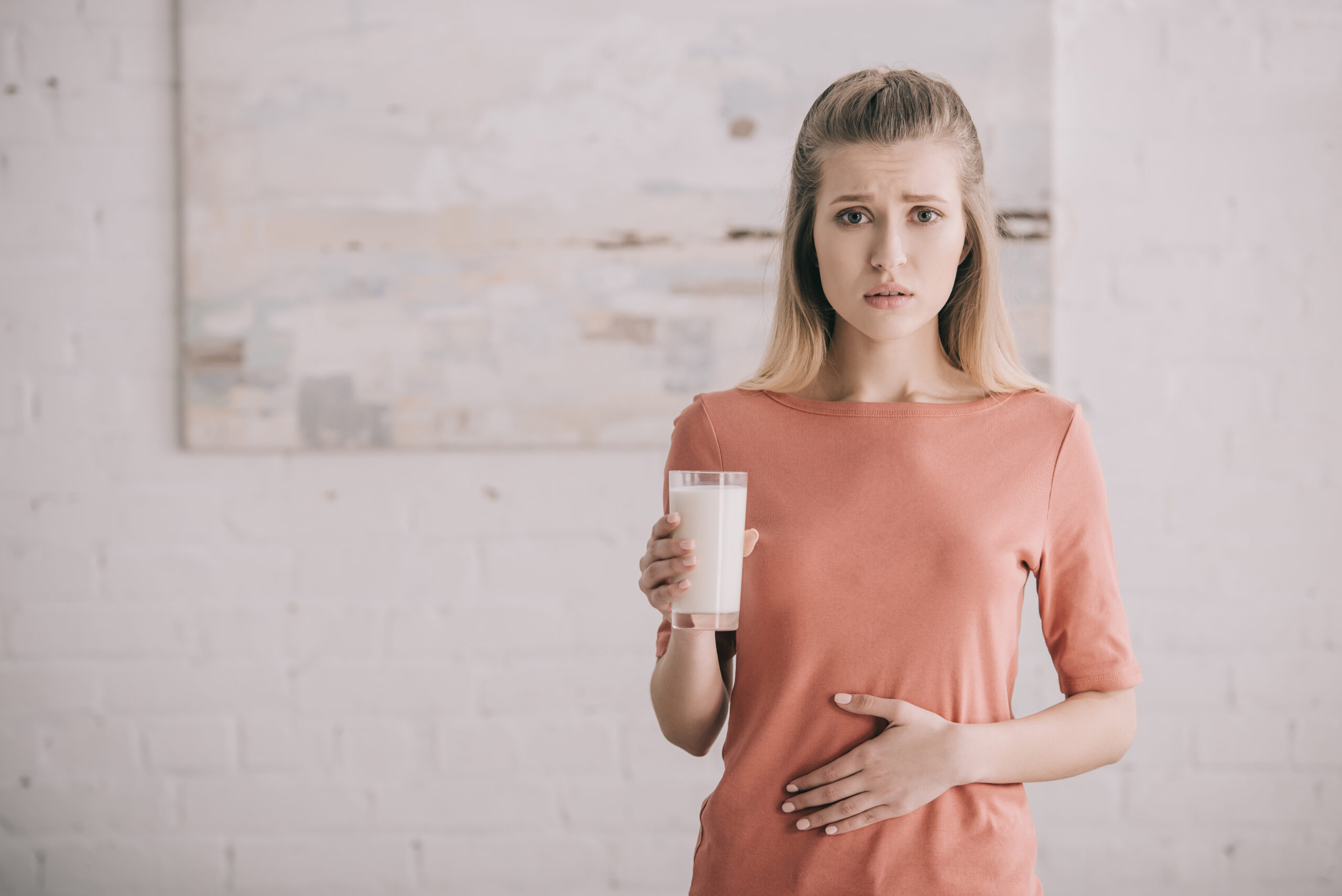 donna con intolleranza al lattosio con bicchiere di latte