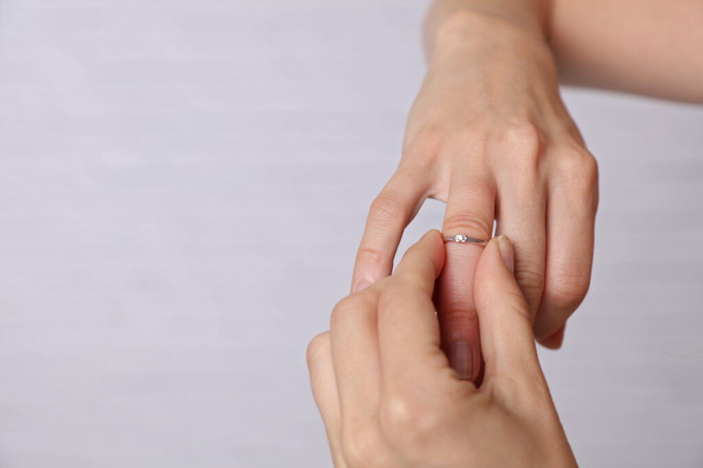 Donna prova a togliersi l'anello con difficoltà a causa delle mani gonfie