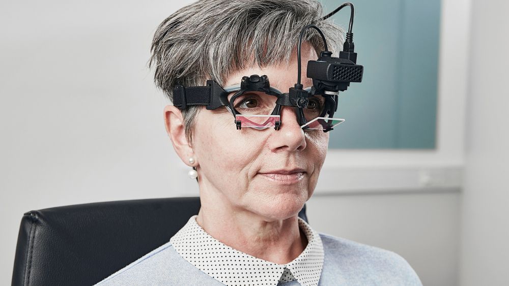 Donna con apparecchio visivo per studiare le vertigini