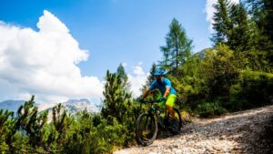 Uomo in bicicletta in un sentiero di montagna - La medicina più potente che abbiamo? L’esercizio fisico