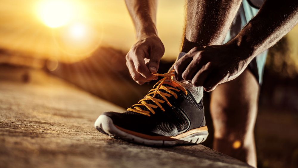 Una persona si allaccia la scarpa pronto per iniziare una sessione di allenamento - Sport e wellness 