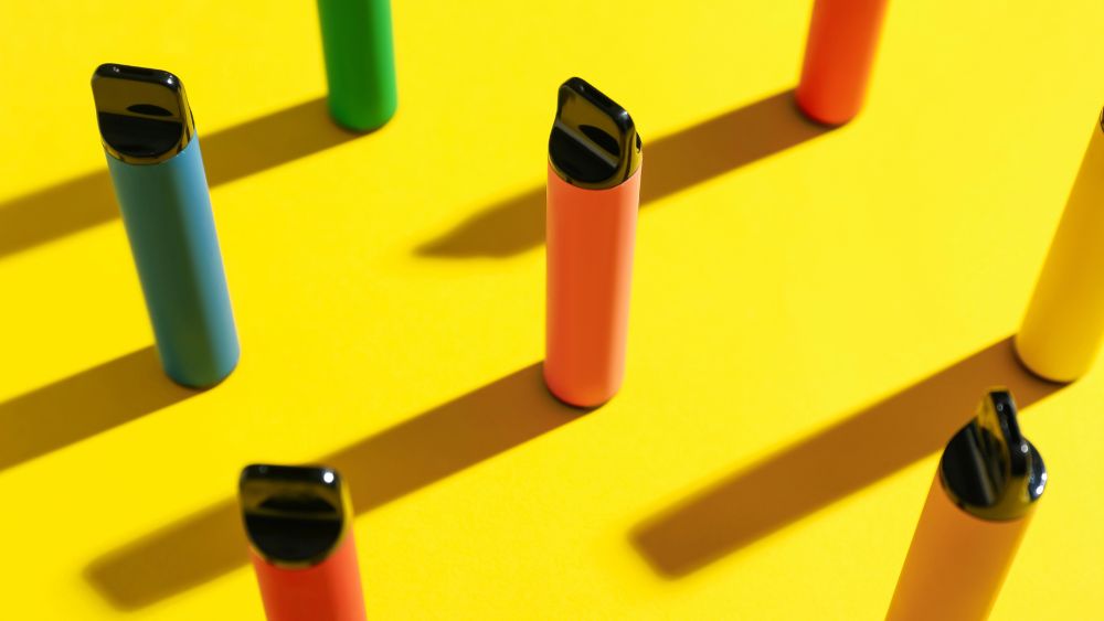 tavolo giallo con sopra sigarette elettroniche - Vaping e salute