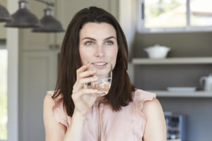 Immagine raffigurante ragazza che beve un bicchiere d'acqua