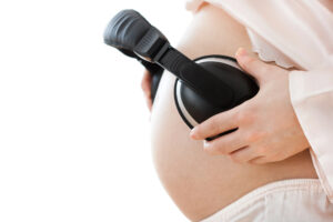 L'immagine rappresenta una donna che fa ascoltare della musica al proprio bambino